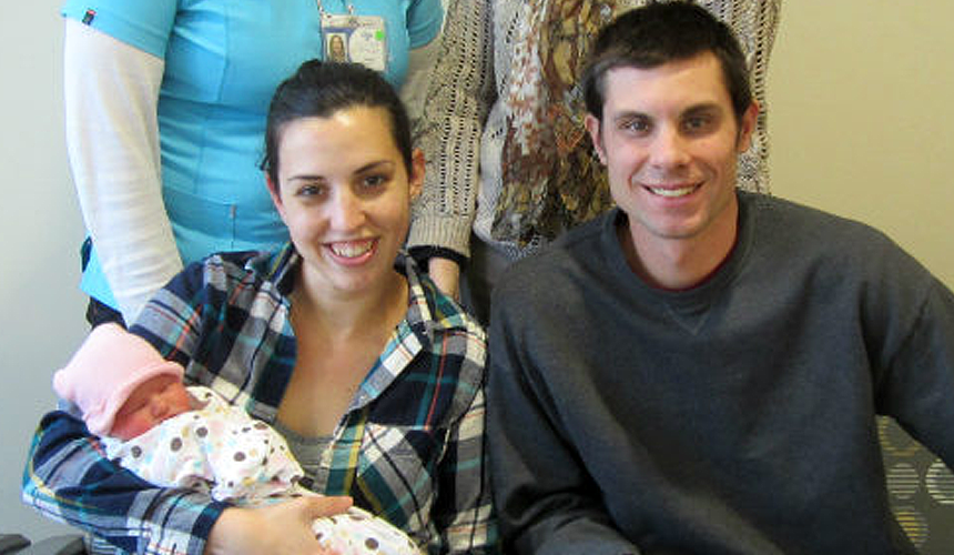 First Baby 2018 Interior photo, smiling man and woman holding first baby of 2018. Glacial Ridge Health System.