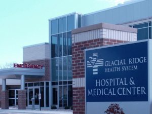 Exterior entrance of building and sign that reads Glacial Ridge Health System Hospital & Medical Center.