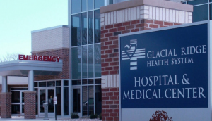 Exterior entrance of building and sign that reads Glacial Ridge Health System Hospital & Medical Center.