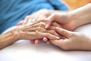 Closeup of hands. Young woman holds hand of older woman.