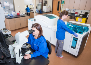 Interior photo of a hospital laboratory and three female lab staff working.