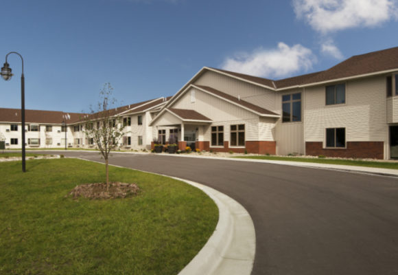 Paved driveway curves around the exterior building entrance.