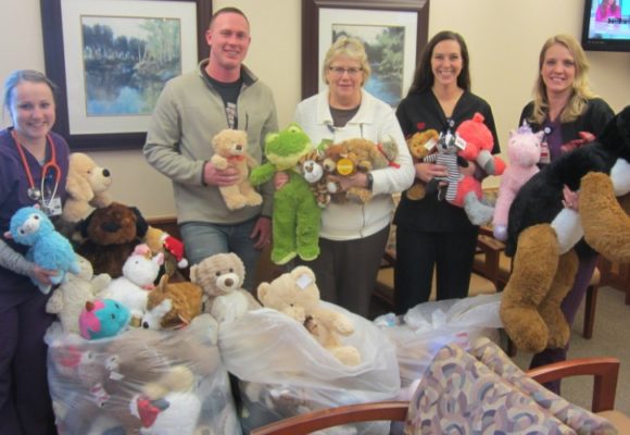 Group of adults holding teddy bears.