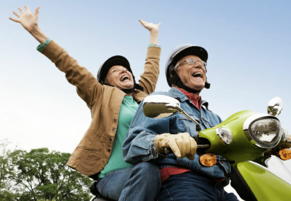 Older couple on a scooter.