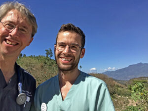 Two male doctors pose with mountains of Honduras in the background.
