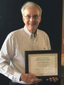 Senior man holding a framed certificate.