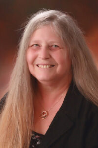 Professional headshot of a woman with long hair.