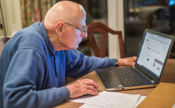 Elderly man using a laptop at home
