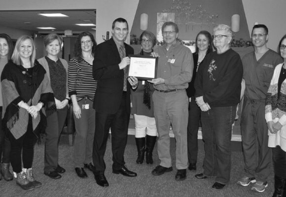 greyscale photo of business people with plaque