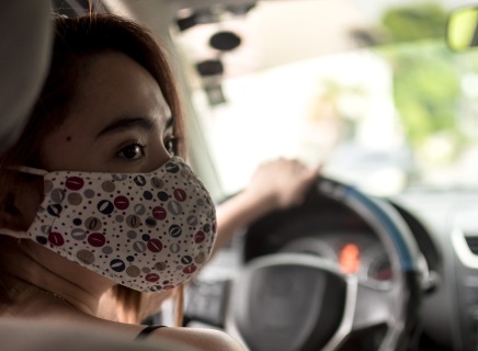 masked woman in car