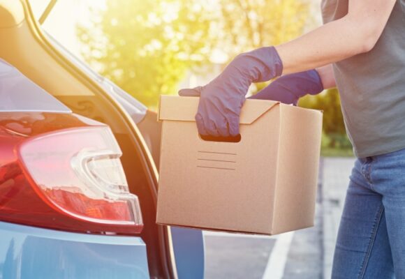 Woman loads box in trunk