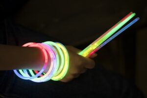 hand with glow sticks in dark