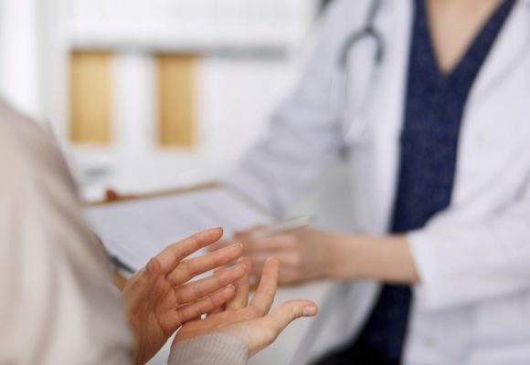 Doctor and patient discussing current health examination while sitting in clinic.