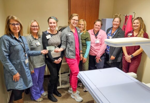 Radiology employees receive a check from the Auxiliary President