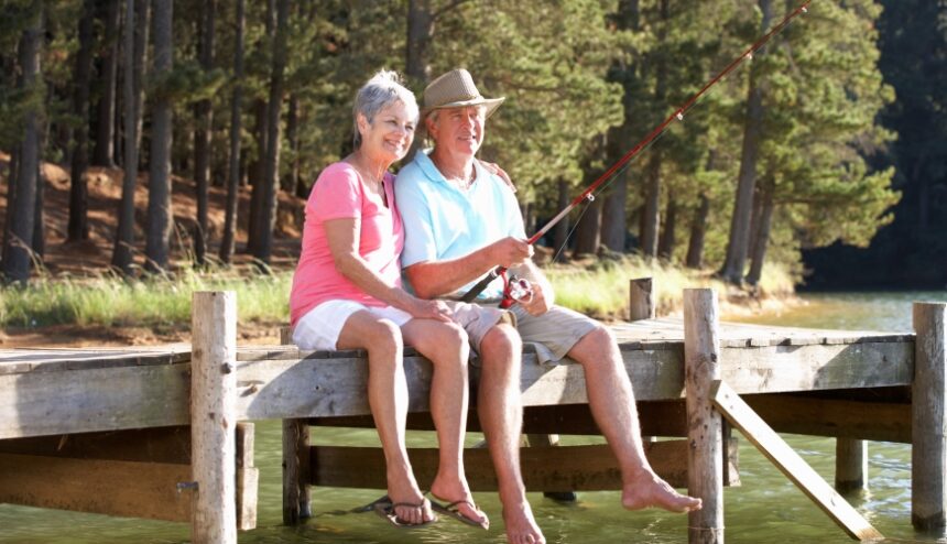 Man and woman fishing, sitting on a dock in the summer