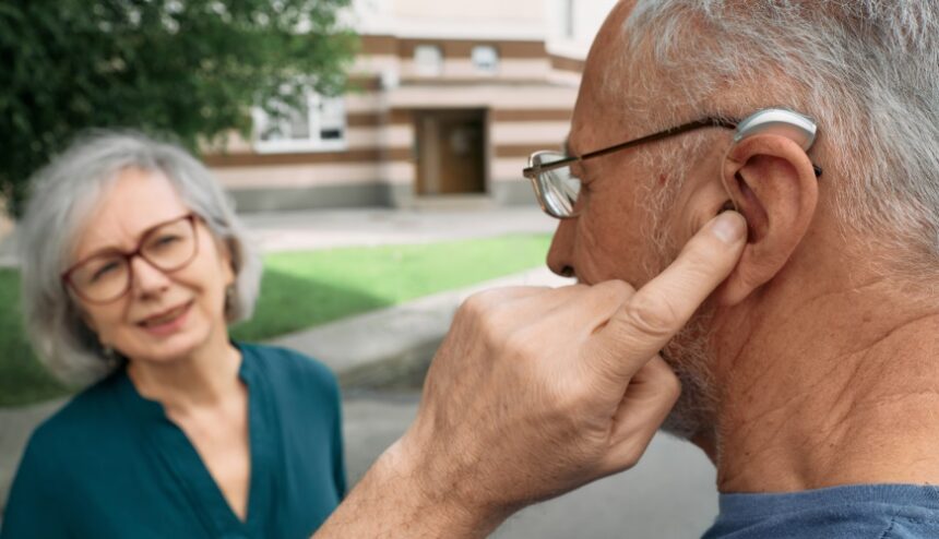 Mature man with a hearing aid and senior woman friend