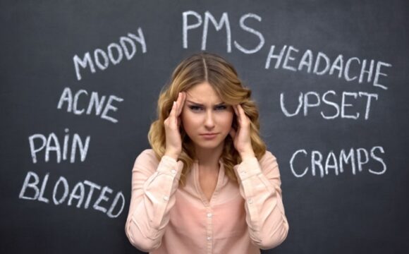 perplexed woman with hands on sides of her head and words on blackboard