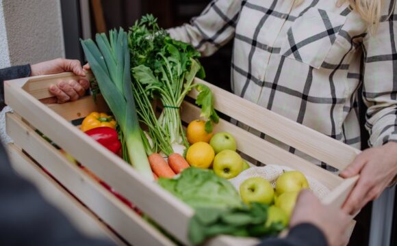 giving a crate of colorful fresh produce