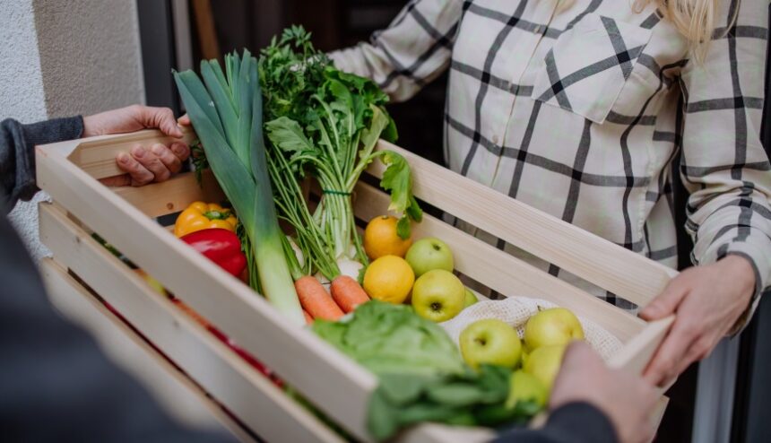 giving a crate of colorful fresh produce