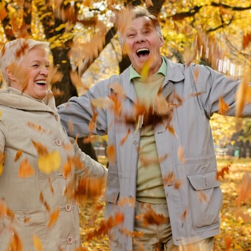 happy couple with falling leaves in a park