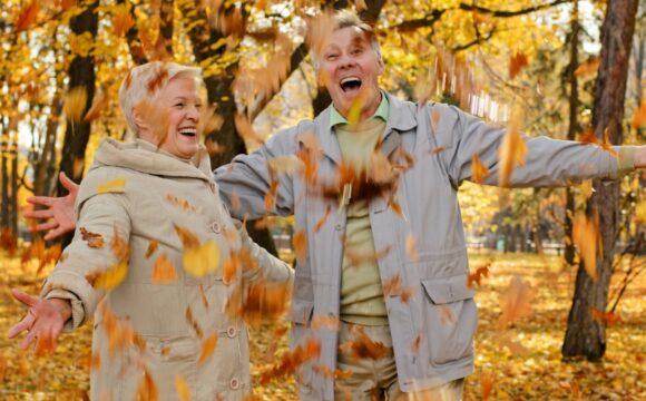 happy couple with falling leaves in a park