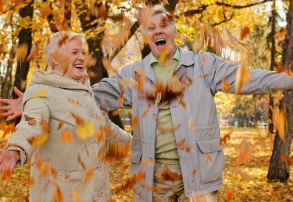 happy couple with falling leaves in a park