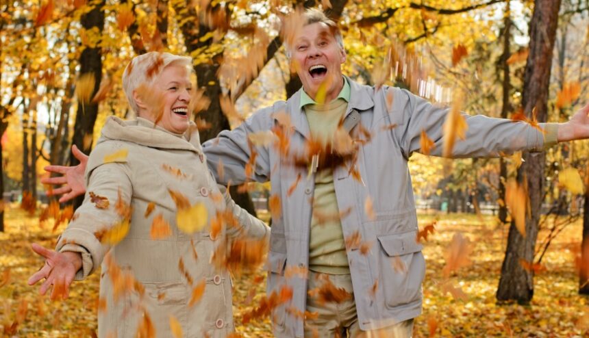 happy couple with falling leaves in a park