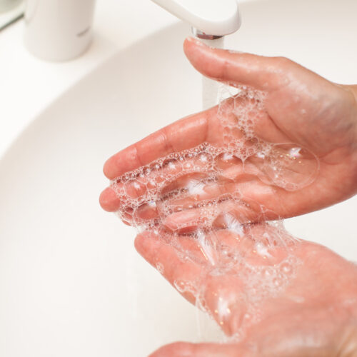 close up photo of woman washes her hands with soap and water