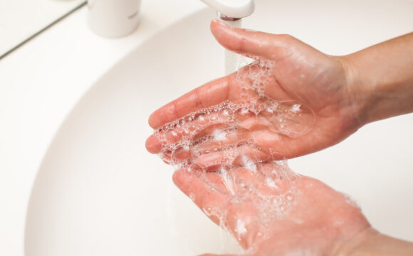 close up photo of woman washes her hands with soap and water