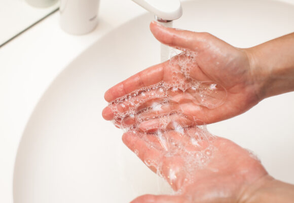 close up photo of woman washes her hands with soap and water