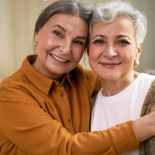 two cheerful women looking at camera with happy smile