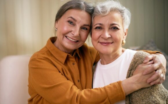 two cheerful women looking at camera with happy smile