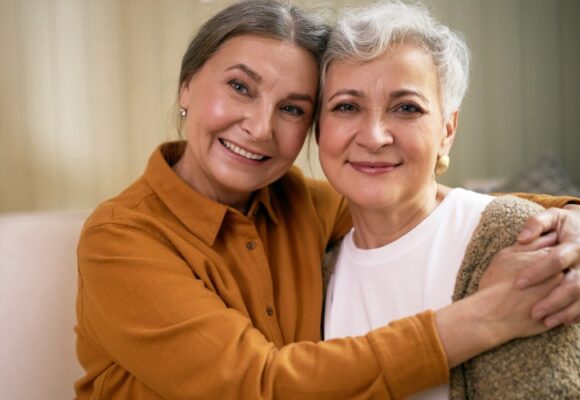 two cheerful women looking at camera with happy smile