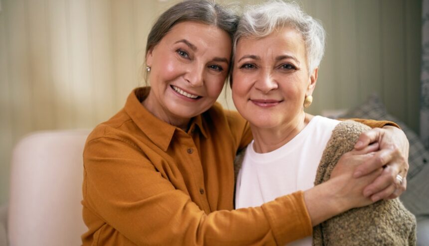 two cheerful women looking at camera with happy smile