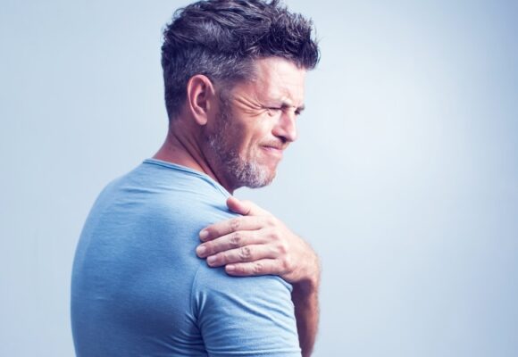 Man grimacing with shoulder pain