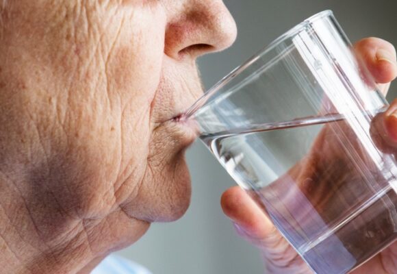Side view of elderly woman drinking water